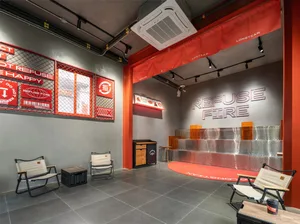 Modern dining room with a red floor, white ceiling, and dim lighting, featuring a dining table and chairs, a refrigerator, and a sink