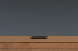 A room with a wooden table and a circular object on top, set against a grayish-brown background