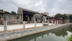 A rustic building with a brick facade and stone-like texture, situated next to a body of water with a boat in the distance, creating a serene atmosphere