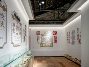 傳統現代客廳，白色地板、玻璃展示櫃、牆上掛鐘、花瓶及多幅畫作，營造獨特且視覺豐富的空間