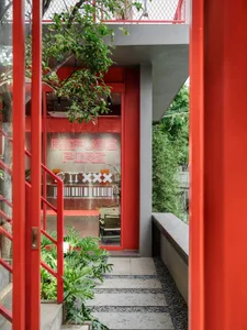 Photograph of a red building with a metal staircase, concrete walls, and natural light from windows