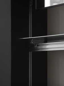 Dimly lit storage space with a metal shelf mounted on the wall, holding various items in a minimalist room