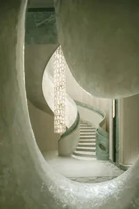 A dimly lit, curved marble staircase dominates the space, with no other objects or distractions visible