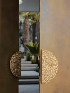 A photograph of a doorway with a golden door, open to a patio area with potted plants, creating a sophisticated and relaxing atmosphere
