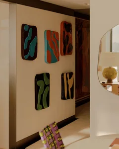 A modern room with a white wall and a mirror, featuring a collection of artworks and a clean minimalist design