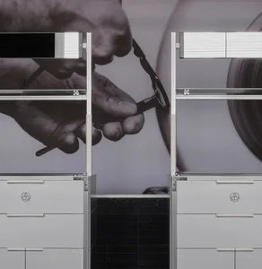 A professional workspace with two gray modern filing cabinets against a wall, one on the left and one on the right, with a person possibly working or organizing the space