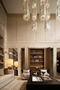 A well-lit living room with a couch, chair, bookshelf, and lamps, creating a cozy and inviting atmosphere for relaxation and leisure
