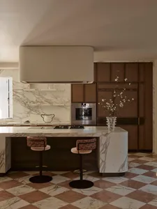 Modern kitchen with a marble countertop, center island, and natural light from a large window