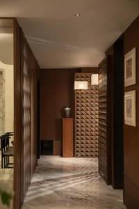 A well-lit modern hallway with wood walls, lined with pictures and chairs, creating a warm and inviting atmosphere