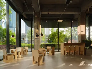 Bright and inviting restaurant with wooden tables and chairs, large windows, and artwork on the walls