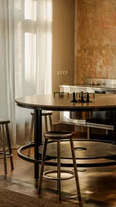 A residential kitchen with a dining table and chairs, black and white color scheme, and natural light creating a bright and clean atmosphere