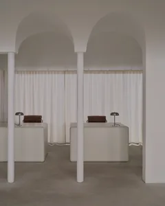 Two white desks with chairs and lamps in a clean and organized room with a focus on functionality and efficiency