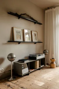 Cozy modern living space with a bookshelf, TV, couch, and lamp, well-lit with a contemporary style