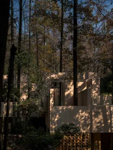 A calm and inviting residential space with a mix of concrete and wood materials, natural light, and a large window