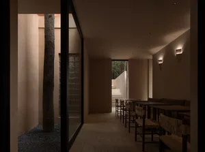 一間燈光充足的現代風格餐廳，設有用餐區與桌椅，以及附有吧檯與吧椅的吧台