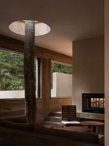 Cozy living room with a stone fireplace, a couch, a chair, and a dining table, creating a warm and inviting space for relaxation and socializing