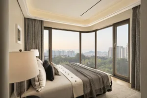 Cozy bedroom with a striped bed, a lamp, and a chair, featuring a large window with a city view and natural light