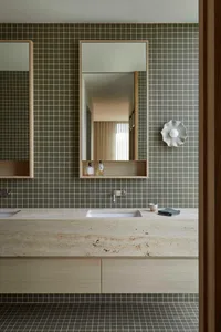 Bathroom with a sink, mirror, and tile wall in a dimly lit space