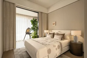 Cozy bedroom with a white bed, a potted plant, and a picture on the wall, set against a white color scheme