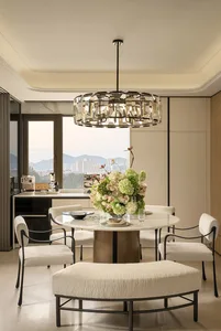 Dining room with a round table surrounded by chairs, a vase with flowers, and a modern style, with natural lighting creating a warm and inviting atmosphere