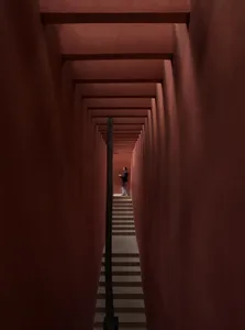 Narrow hallway with a red brick wall, a staircase, and architectural details