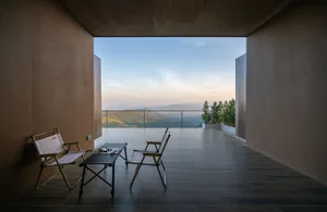 Comfortable living space with a wooden floor, a large window, and a dining table with chairs, well-lit and inviting