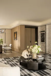 Elegant living room with hardwood floor, marble table, and natural light from a large window
