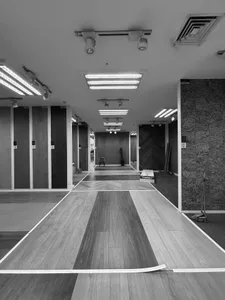 A large, open room with wooden floors and ceiling, well-lit by natural light through windows