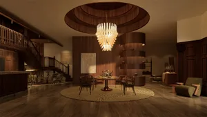 A well-lit living room with a chandelier, chairs, a dining table, and a potted plant, creating a warm and inviting atmosphere
