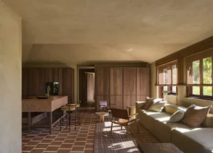 A well-lit living room with a tile floor, wooden furniture, and decorative items creating a warm and inviting atmosphere