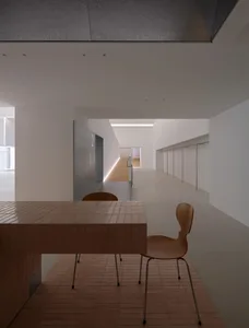 溫馨餐廳空間，棕色餐桌搭配大理石桌面，周圍為白色牆面與少量棕色元素，營造昏黃舒適氛圍
