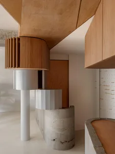 Well-lit kitchen with wooden cabinets, concrete countertops, and a modern design