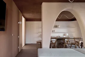 Cozy modern living dining space with a white color scheme, a couch, dining table, chairs, and a kitchen area with a sink