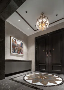 A dimly lit hallway with a chandelier, marble, and wood features, creating a cozy and intimate atmosphere