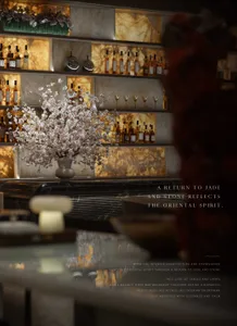 A modern bar with a marble countertop, bottles, and a vase with flowers, creating a sophisticated and inviting atmosphere