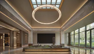 A large, open room with a high ceiling, featuring a detailed city model on a table, in a bright and even lit modern architectural setting