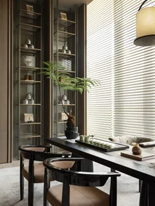 Cozy modern living space with a dining table, chairs, a couch, and a vase, surrounded by wood and glass surfaces, with natural light and a warm atmosphere