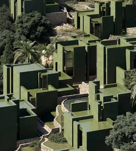 A modern green building with a unique design, featuring a combination of green and black colors, and numerous windows allowing for natural light