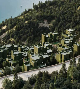 A modern building with a green facade, surrounded by trees, near a body of water, featuring a mix of traditional and contemporary architectural elements