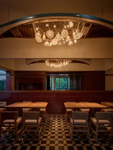 A warm and inviting restaurant interior with wooden tables and chairs, set with various items and pleasant lighting