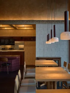 Warm and inviting restaurant interior with a wooden table, stone elements, and soft warm lighting