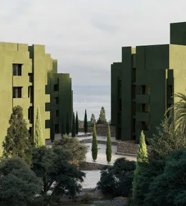 A modern green building with a mix of green and brown colors, surrounded by trees, and well-lit with natural light from the windows