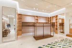 A well-lit room filled with wooden shelves and cabinets, housing a collection of books and other items, with glass surfaces visible on the shelves and cabinets