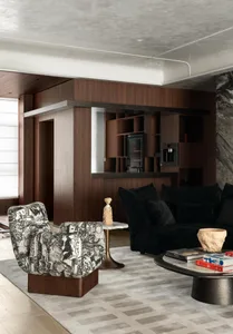 Modern living room with black and white patterned armchair, walnut wood built-in bar, black velvet sofa, marble side table, and grey area rug