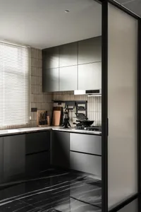 Modern minimalist kitchen interior with dark grey handleless cabinets, white marble countertops, black marble floor tiles, and wood slat accent wall beside a window with white blinds.