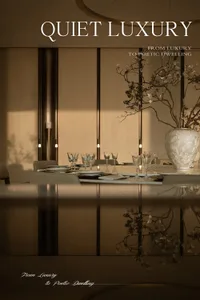 Elegant modern dining room featuring a long white marble table set with crystal glassware, neutral upholstered chairs, and a large textured white ceramic vase holding delicate cherry blossom branches, illuminated by soft vertical wall sconces.