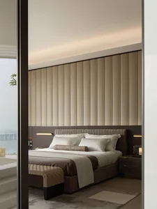 Modern luxury bedroom with taupe velvet panelled headboard, white striped bedding, woven bench, and large window overlooking water.