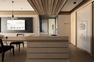 Modern open-plan kitchen and dining area featuring a large concrete kitchen island with oak base, black dining chairs, wooden slat ceiling, and a large black-and-white photograph on the wall.