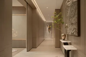 Modern minimalist hallway featuring light wood paneling, recessed lighting, marble console table with bronze vase and potted tree, and large Chinese ink painting on the wall.