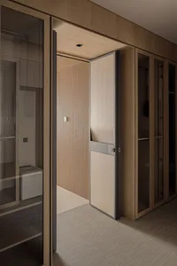 Modern walk-in closet interior with light oak cabinetry, a ribbed wooden sliding door, and neutral carpeted flooring.